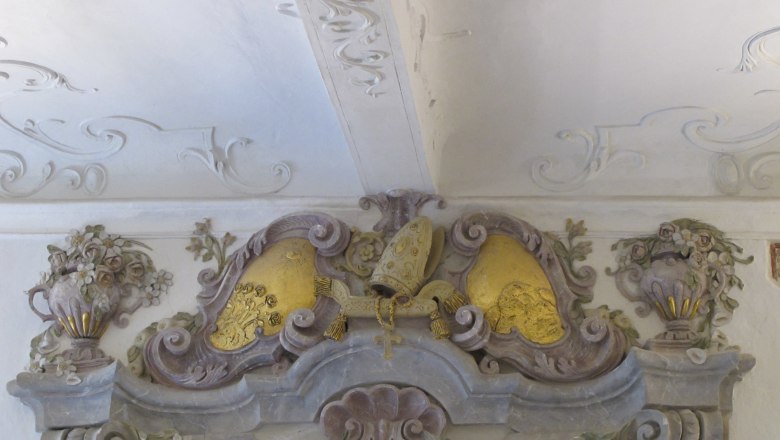 Prachtvolle Verzierungen, © Jutta Mucha-Zachar Barocke Stuckverzierung mit floralen Motiven und goldenen Elementen an einer Decke.
