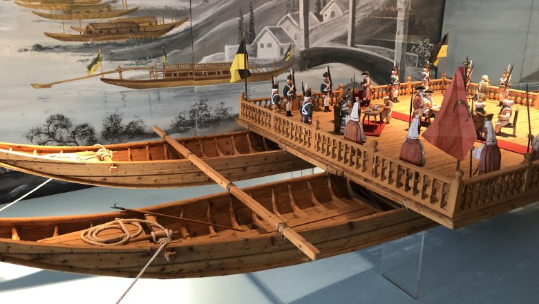 Ausstellungsobjekt im Schifffahrtsmuseum, © Donau Nö Tourismus/JS Modell eines historischen Schiffs mit Figuren in einem Museum.