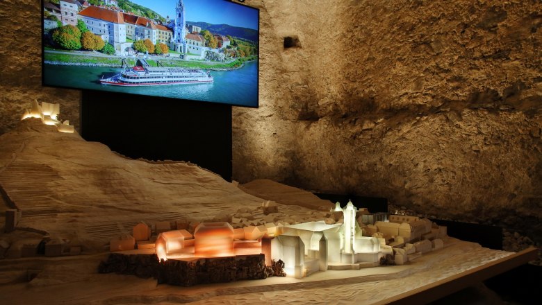 Modell von D&uuml;rnstein mit beleuchtetem Stift und Foto im Hintergrund.