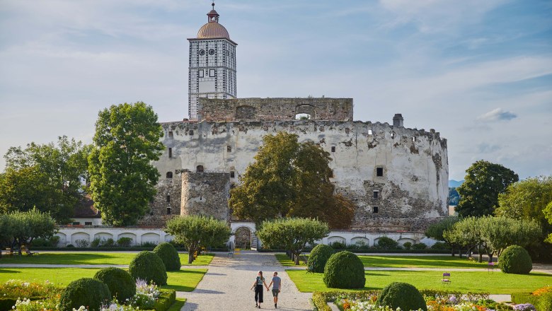 Schloss Schallaburg mit Garten und zwei Personen auf einem Weg.
