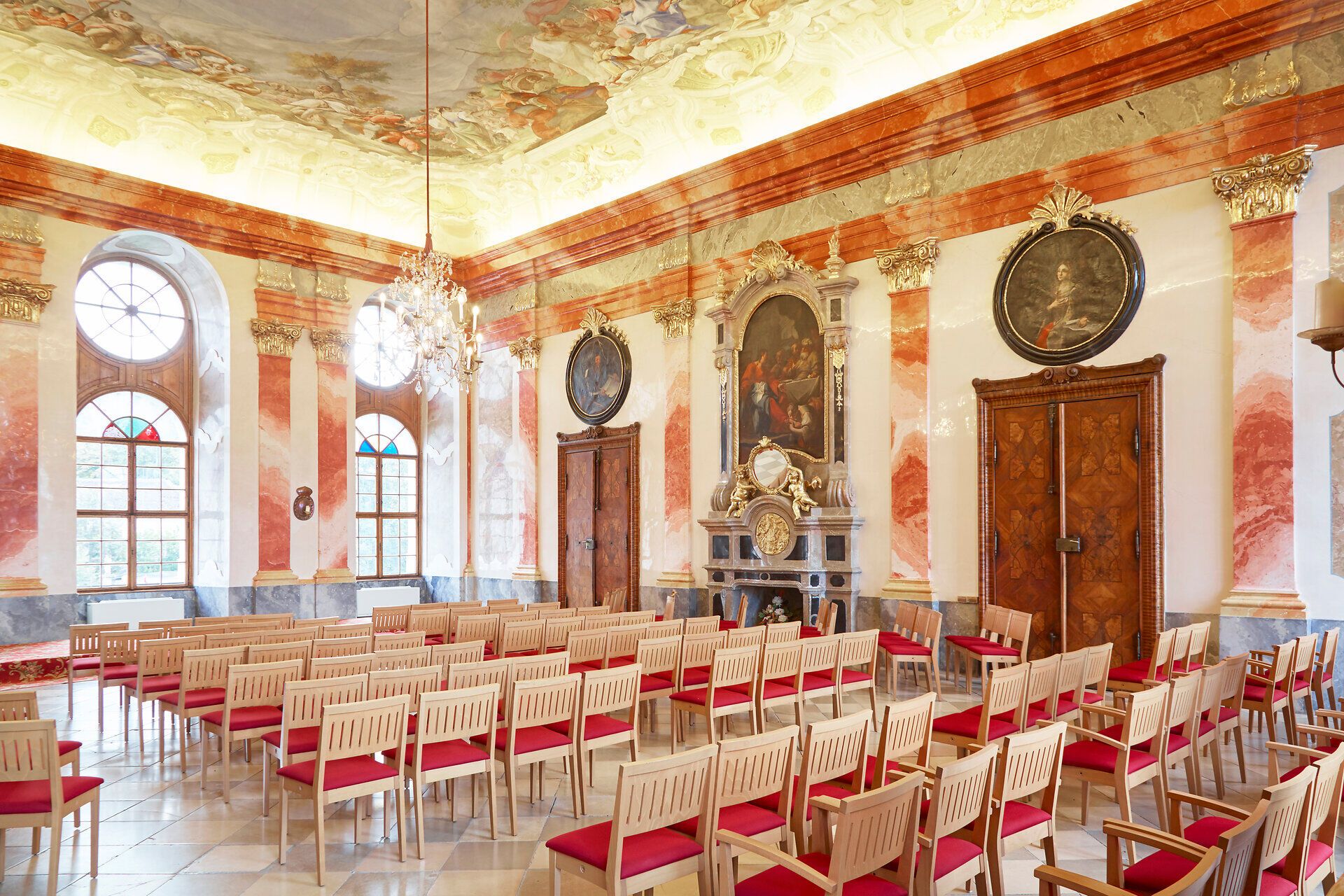 Innenansicht eines prunkvollen Barocksaals mit Stuckdecke und Kronleuchter im Stift Geras.