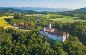 Luftaufnahme der Schallaburg inmitten gr&uuml;ner Landschaft.