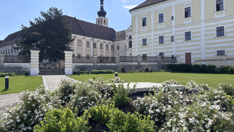 Stift Geras mit Garten und Blumen im Vordergrund.