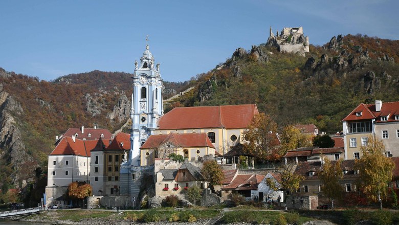 Panorama von D&uuml;rnstein mit Kirche und Burgruine auf einem H&uuml;gel.