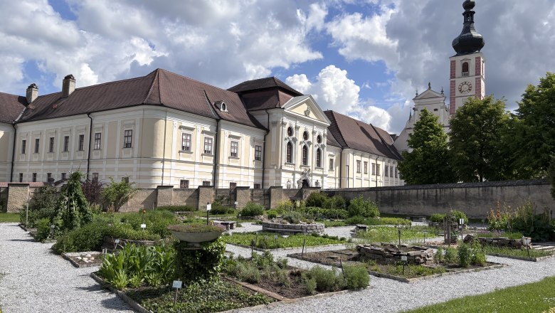 Heilkr&auml;utergarten vor dem Stift Geras mit barockem Geb&auml;ude und Kirchturm im Hintergrund.