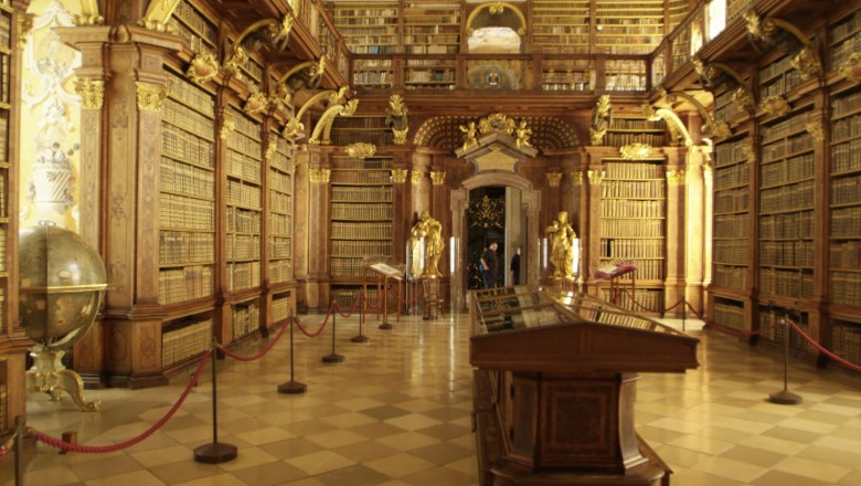 Innenansicht der Bibliothek im Stift Melk mit hohen B&uuml;cherregalen und dekorativen Elementen.